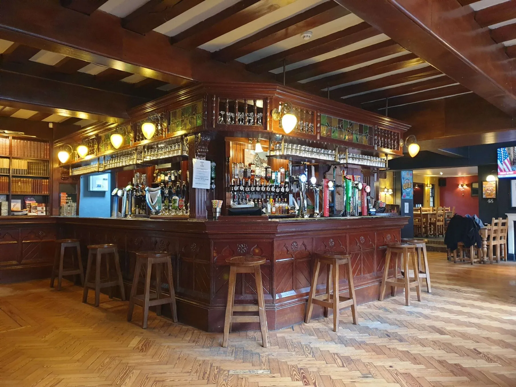 The traditional wood-panelled bar at The Nags Head, with hand pumps and parquet floor