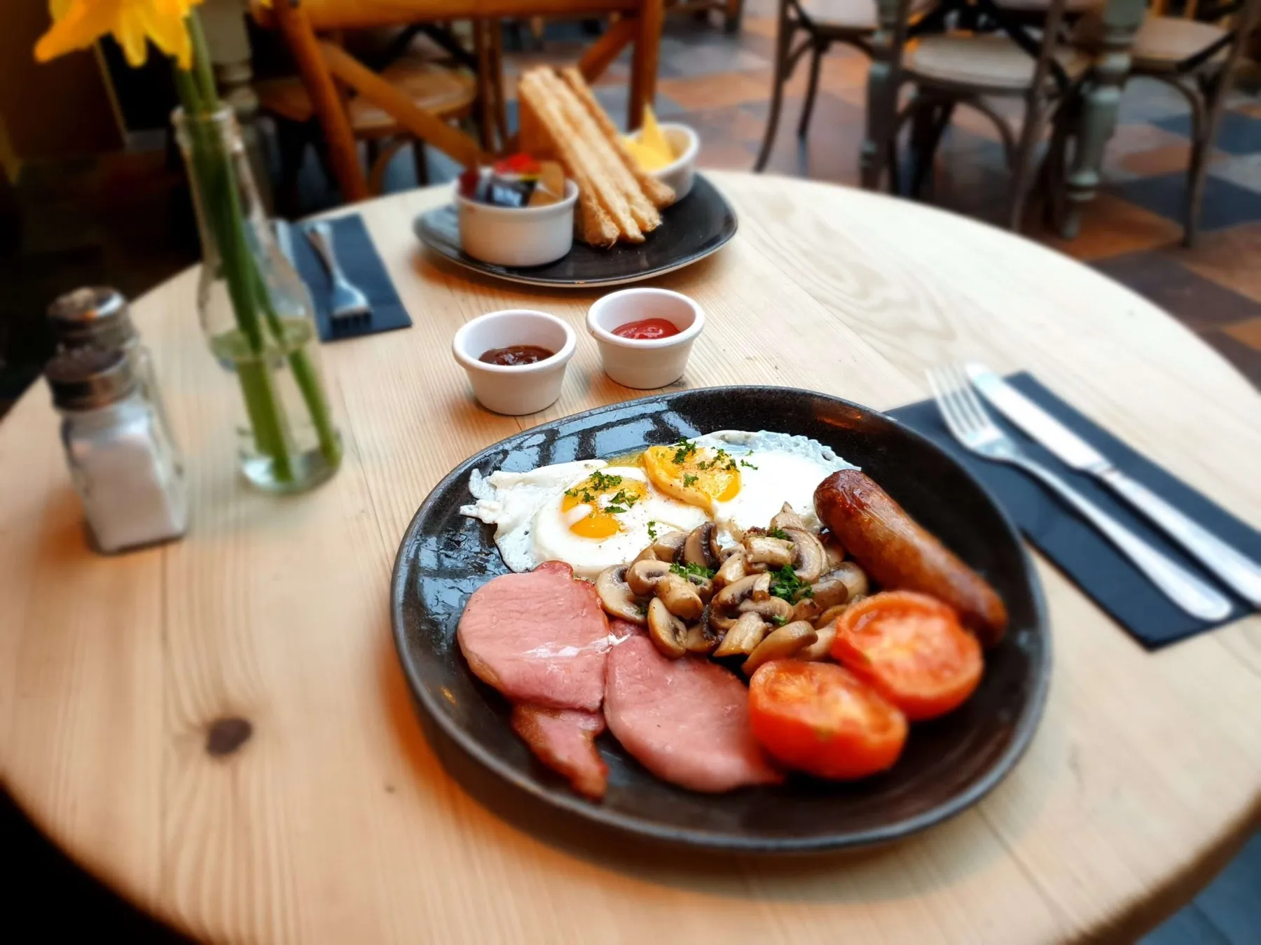 A cooked breakfast served at The Nags Head, with ham, eggs, sausages, mushrooms and tomatoes