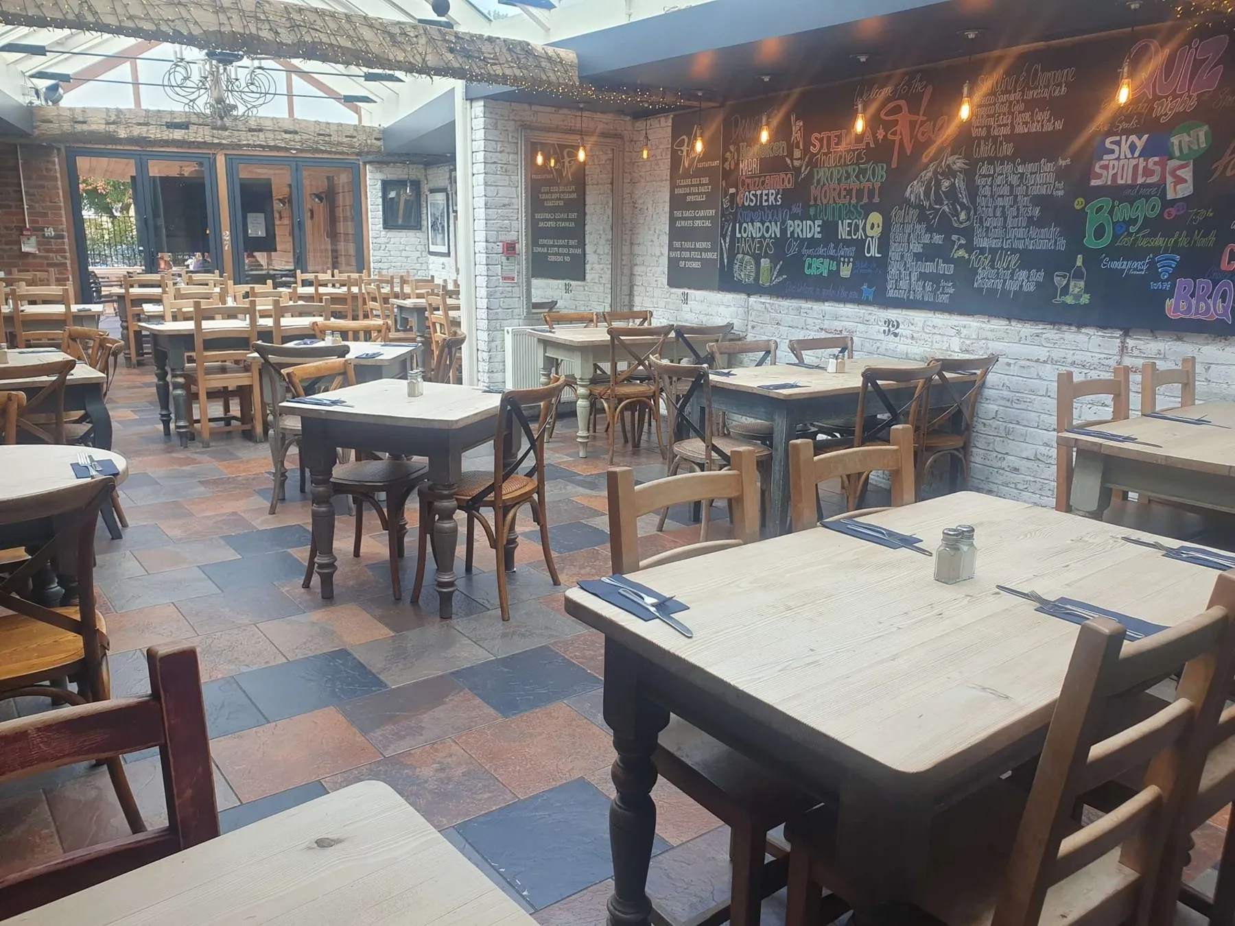 The 180-seat restaurant at The Nags Head under its greenhouse-style roof, with chalkboard walls
