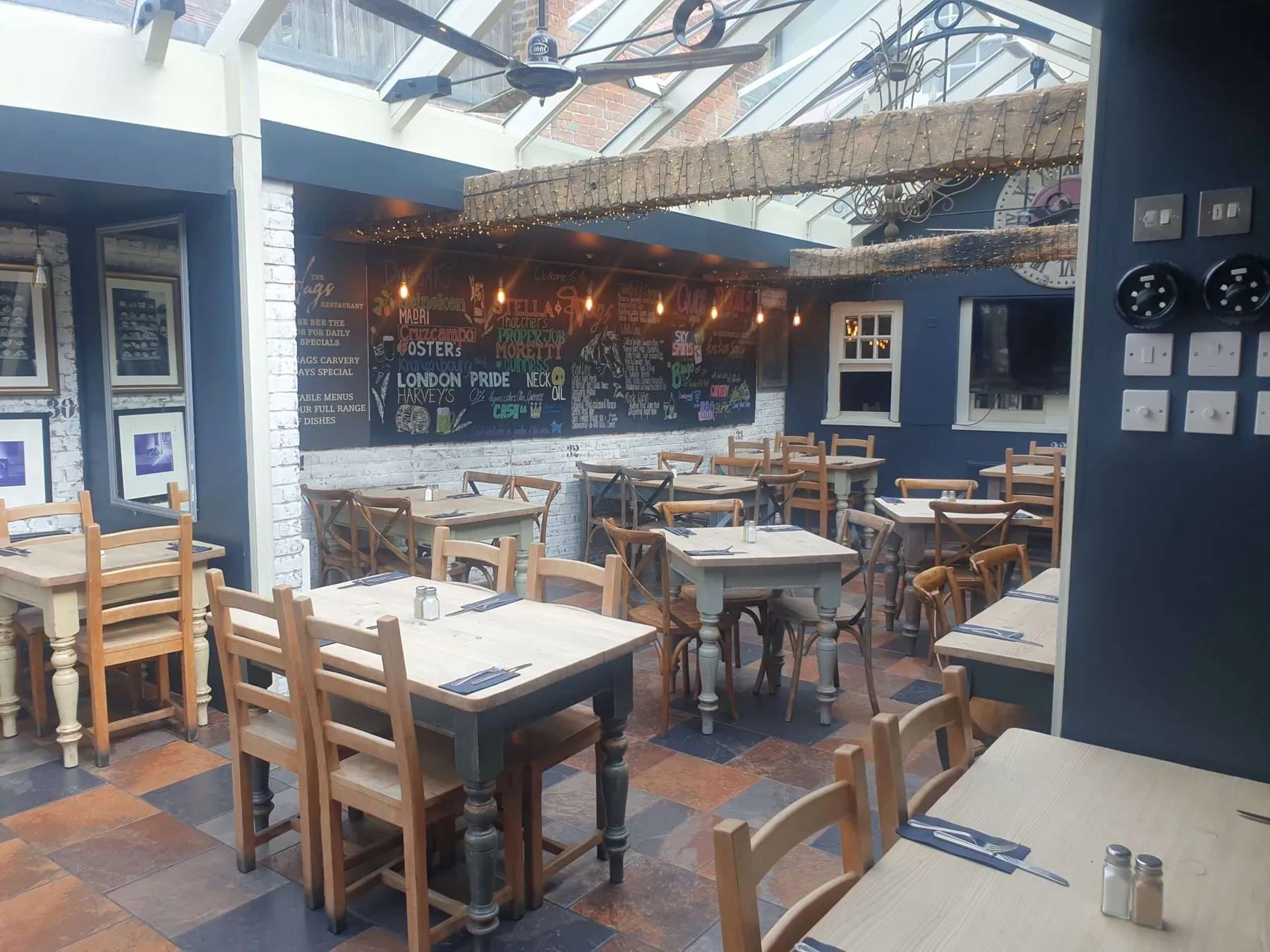Tables set for a group under the glass roof of The Nags Head restaurant