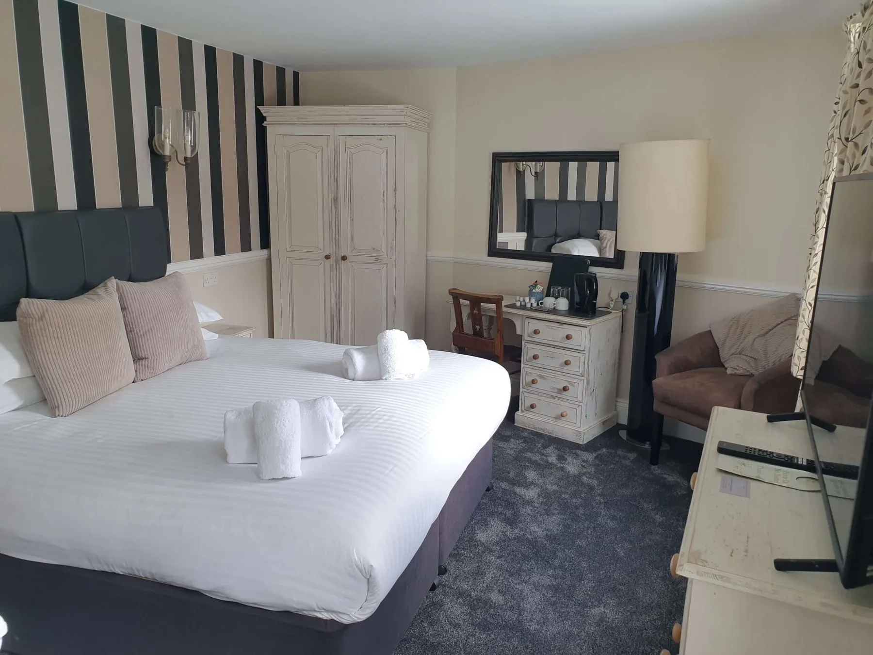 A double room at The Nags Head hotel with striped feature wall and grey carpet